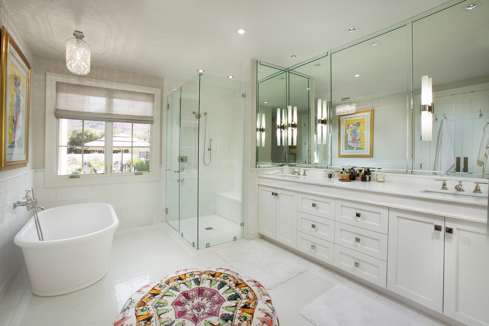 Идея дизайна: главная ванная комната в стиле неоклассика (современная классика) с фасадами в стиле шейкер, белыми фасадами, отдельно стоящей ванной, угловым душем, белой плиткой, белыми стенами, врезной раковиной, белым полом, душем с распашными дверями, белой столешницей и зеркалом с подсветкой