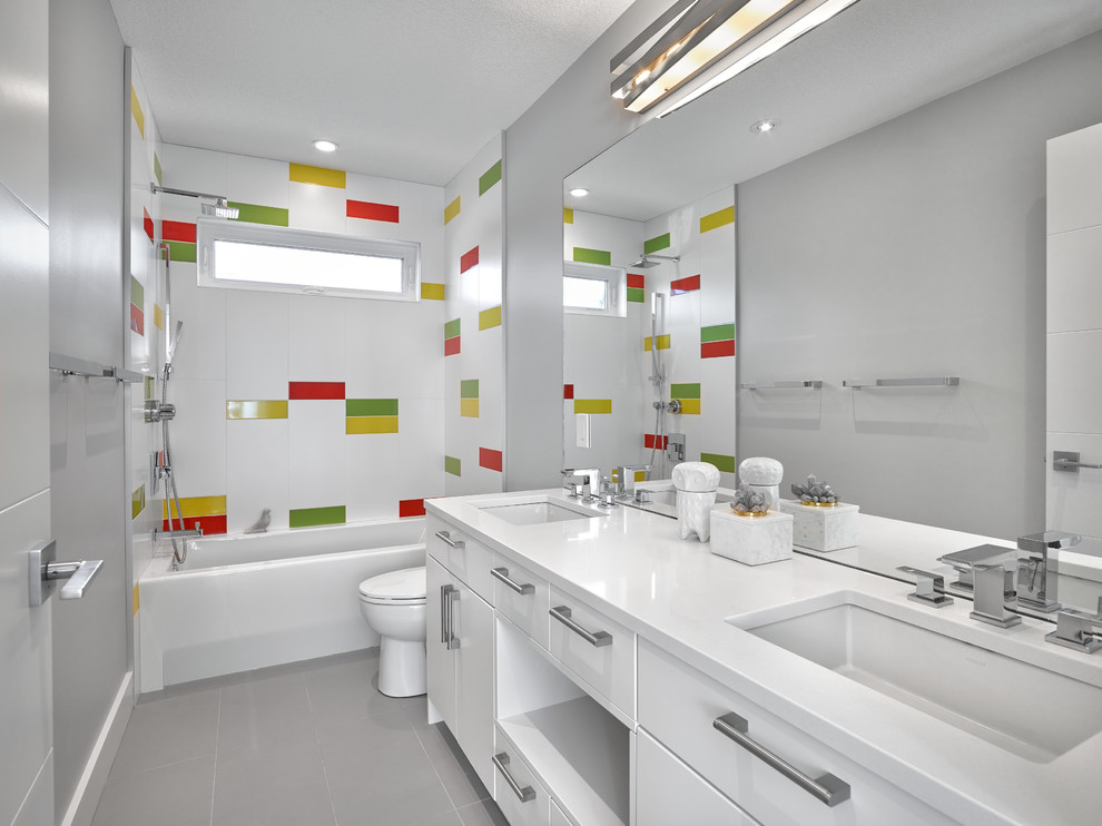 Inspiration för moderna badrum, med släta luckor, vita skåp, ett badkar i en alkov, en dusch/badkar-kombination, grå väggar, ett undermonterad handfat och grått golv