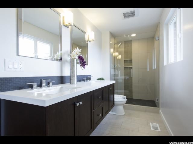 Example of a large minimalist 3/4 blue tile and porcelain tile porcelain tile alcove shower design in Salt Lake City with shaker cabinets, dark wood cabinets, white walls, an undermount sink and quartz countertops
