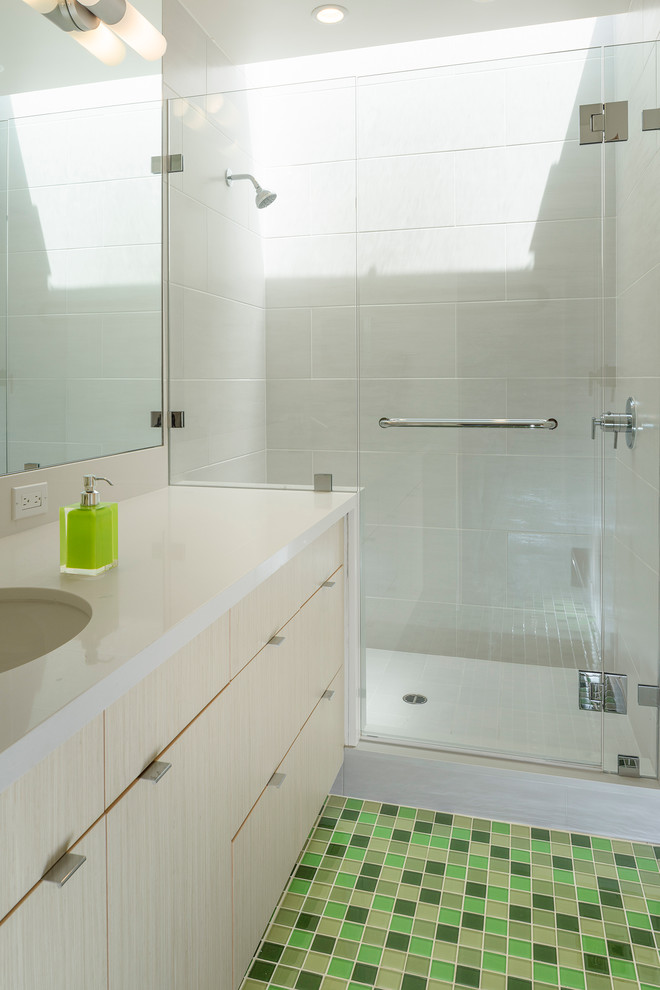 This is an example of a large contemporary family bathroom in San Francisco with a submerged sink, flat-panel cabinets, light wood cabinets, engineered stone worktops, an alcove shower, a one-piece toilet, green tiles, white walls, glass tiles and ceramic flooring.