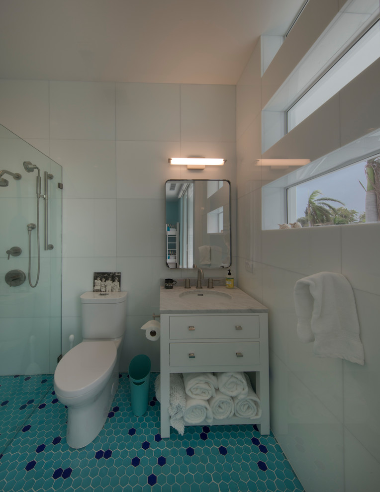 マイアミにある小さなモダンスタイルのおしゃれな浴室 (白いキャビネット、アルコーブ型シャワー、青いタイル、白い壁、磁器タイルの床、青い床) の写真