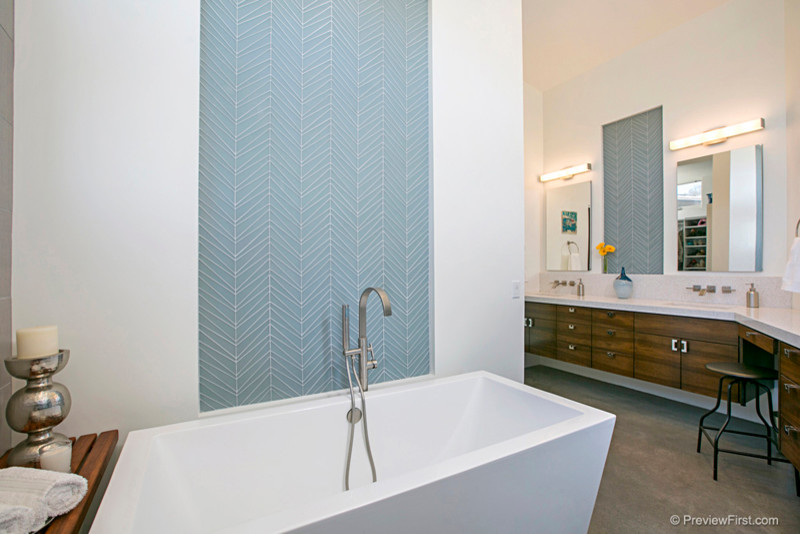 Modern inredning av ett mellanstort en-suite badrum, med släta luckor, skåp i mellenmörkt trä, bänkskiva i kvarts, ett fristående badkar, vita väggar och betonggolv