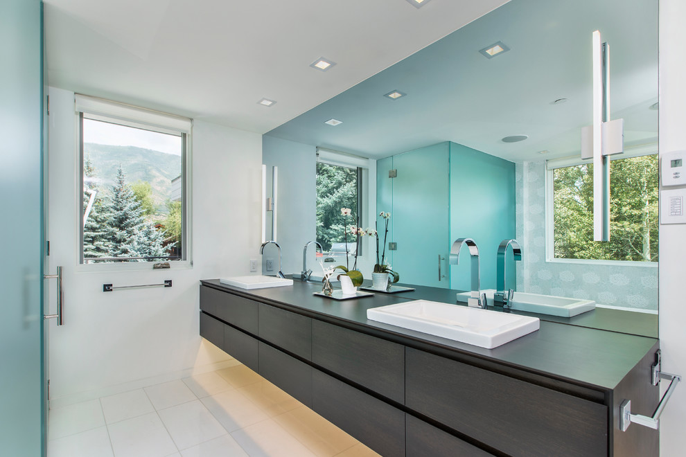 На фото: ванная комната в современном стиле с плоскими фасадами, темными деревянными фасадами, угловым душем, белыми стенами и накладной раковиной