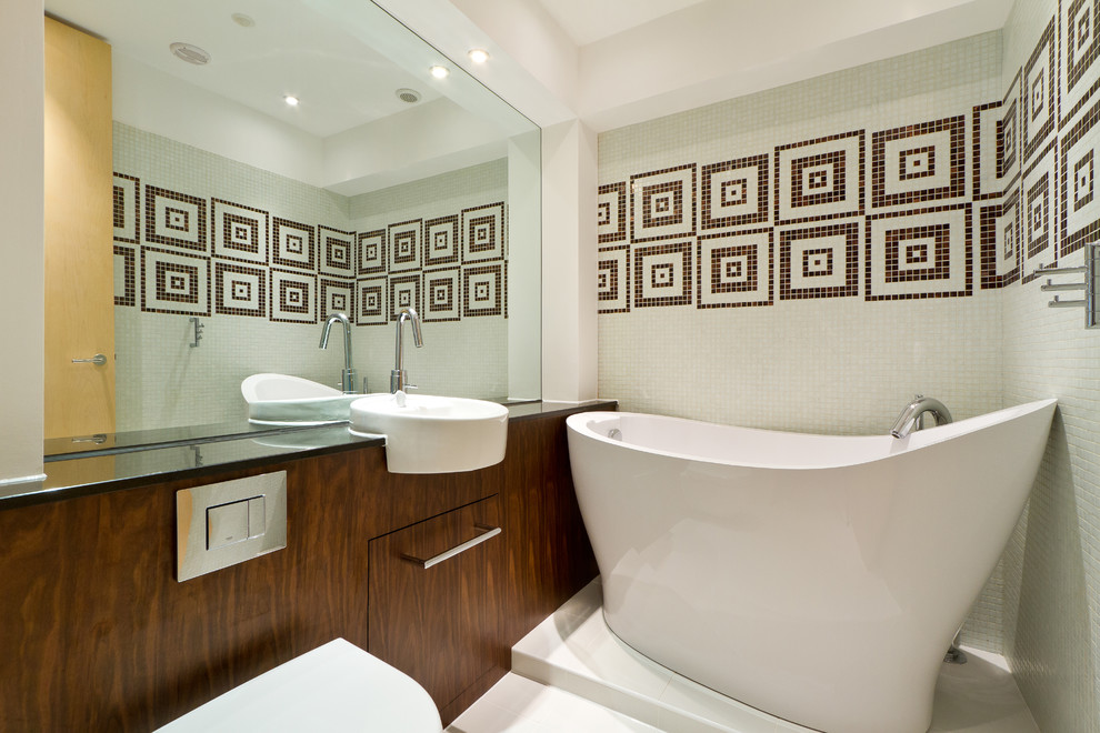 Ejemplo de cuarto de baño actual con bañera exenta, baldosas y/o azulejos en mosaico y lavabo sobreencimera