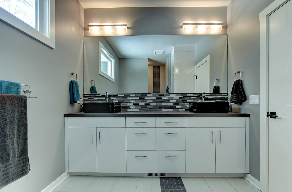 Пример оригинального дизайна: главная ванная комната в стиле модернизм с плоскими фасадами, белыми фасадами, столешницей из ламината, душем в нише, черной плиткой, стеклянной плиткой, серыми стенами и полом из керамической плитки