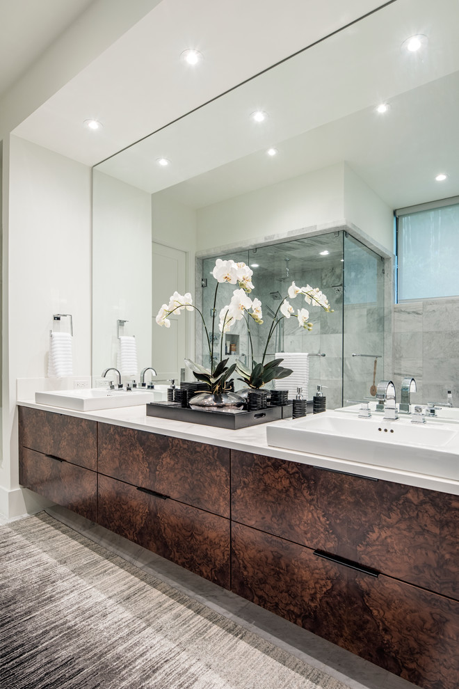 На фото: большая главная ванная комната в восточном стиле с плоскими фасадами, коричневыми фасадами, угловым душем, зеркальной плиткой, белыми стенами, раковиной с несколькими смесителями и мраморной столешницей