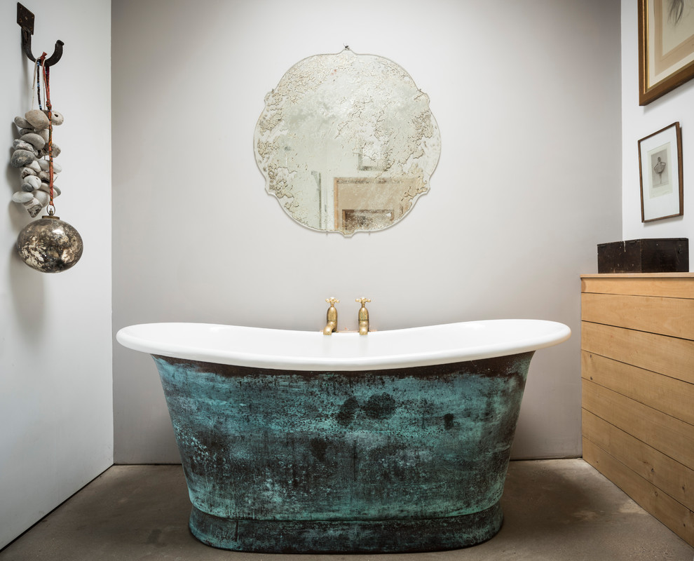 Lantlig inredning av ett mellanstort en-suite badrum, med ett fristående badkar, släta luckor, beige skåp, grå väggar, betonggolv och grått golv