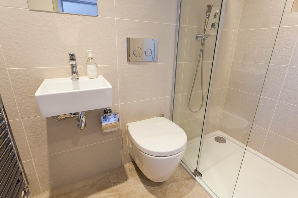 Exempel på ett litet modernt badrum med dusch, med en öppen dusch, en vägghängd toalettstol, beige kakel, porslinskakel, beige väggar, klinkergolv i porslin, ett väggmonterat handfat och kaklad bänkskiva