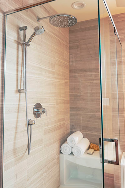 Réalisation d'une petite salle de bain champêtre avec une douche d'angle, WC à poser, un carrelage gris, des dalles de pierre, un sol en bois brun et un lavabo de ferme.