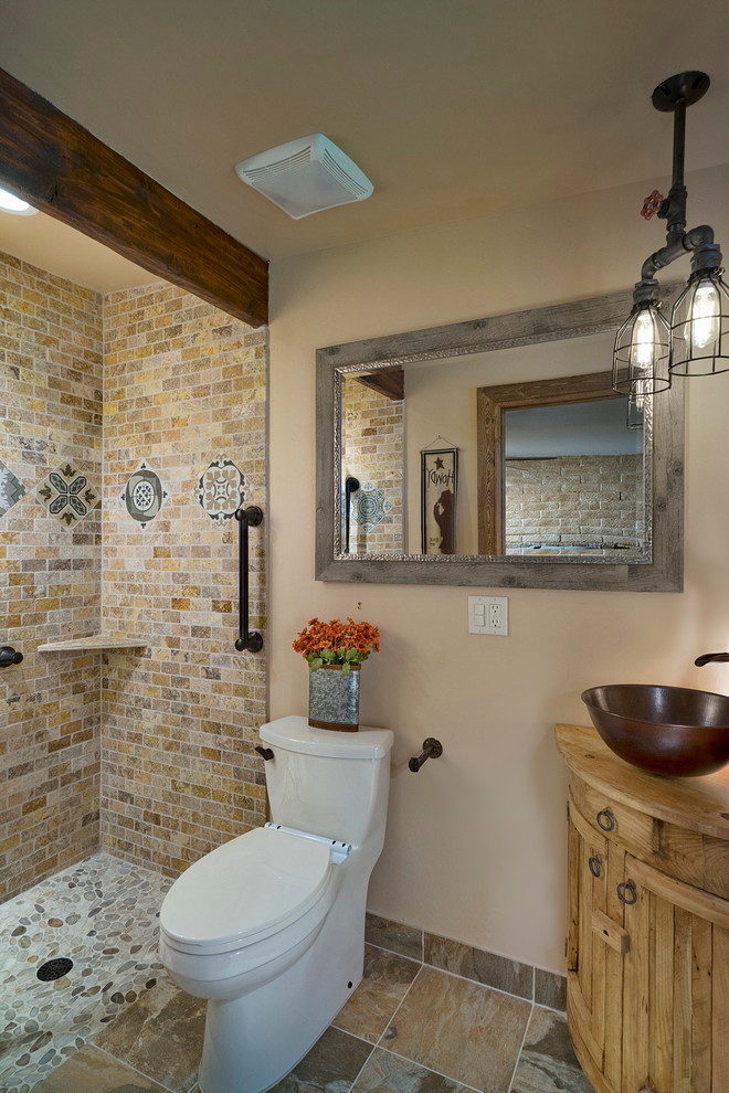 Foto på ett litet rustikt brun badrum med dusch, med klinkergolv i porslin, möbel-liknande, skåp i ljust trä, en öppen dusch, en toalettstol med hel cisternkåpa, beige kakel, porslinskakel, beige väggar, ett fristående handfat och träbänkskiva