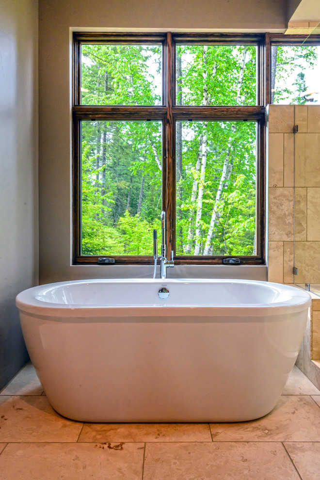 Foto di una stanza da bagno padronale moderna con vasca freestanding, piastrelle beige, pareti grigie e pavimento in travertino