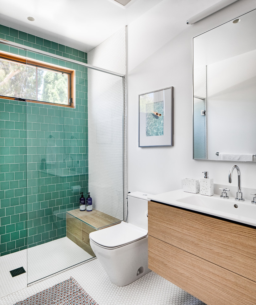 Example of a mid-sized trendy kids' green tile and ceramic tile mosaic tile floor and white floor bathroom design in Orange County with flat-panel cabinets, light wood cabinets, a one-piece toilet, white walls, an integrated sink, quartz countertops and white countertops
