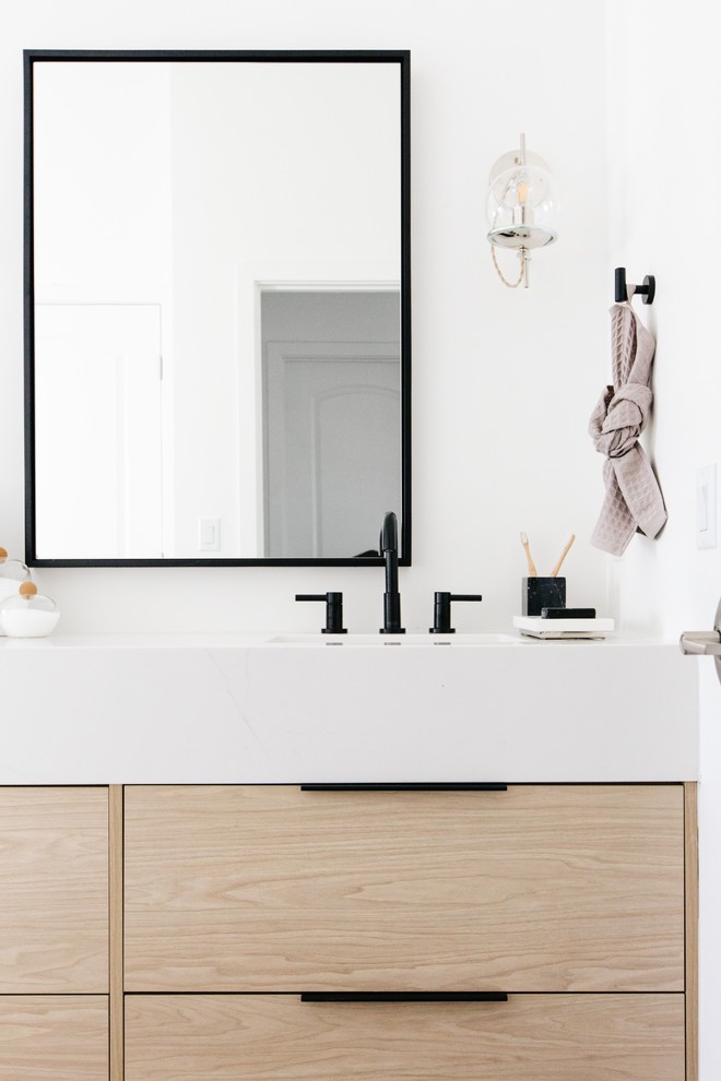 This is an example of a medium sized scandi ensuite bathroom in Phoenix with flat-panel cabinets, light wood cabinets, a freestanding bath, an alcove shower, white walls, ceramic flooring, a submerged sink, quartz worktops, black floors, a hinged door and white worktops.