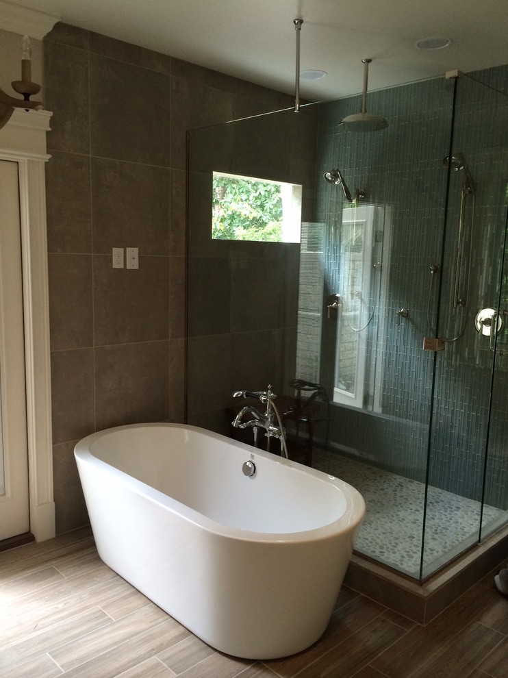 Exemple d'une très grande salle de bain principale tendance avec une baignoire indépendante, une douche ouverte, un sol en carrelage de porcelaine, un carrelage gris et un mur beige.