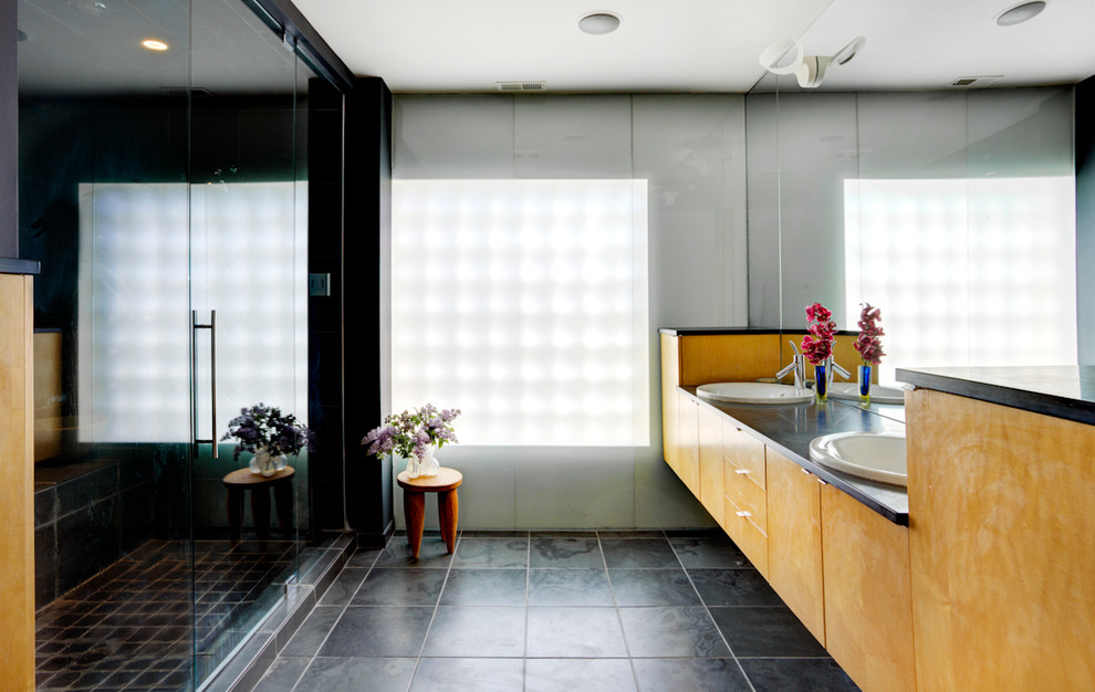 Идея дизайна: ванная комната в современном стиле с накладной раковиной, плоскими фасадами, фасадами цвета дерева среднего тона, душем в нише и черной плиткой