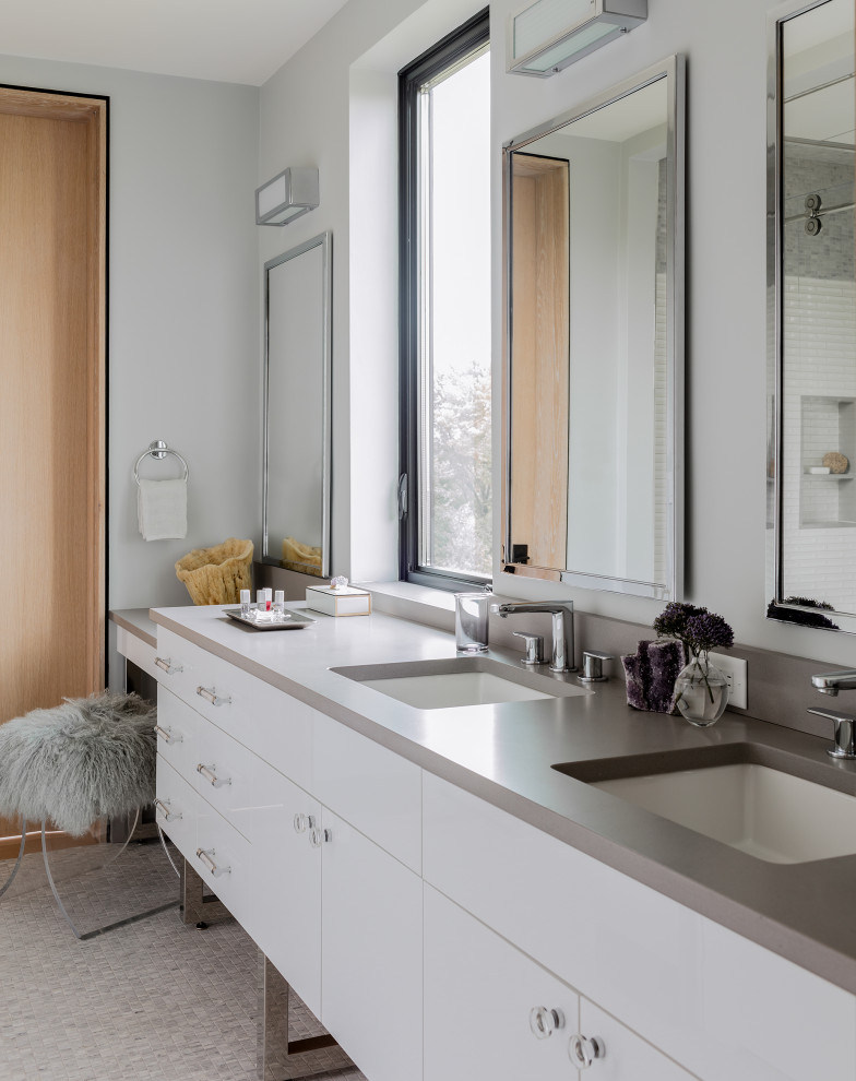 Photo of a contemporary ensuite bathroom in Boston with flat-panel cabinets, grey walls, mosaic tile flooring, a built-in sink, grey floors and double sinks.
