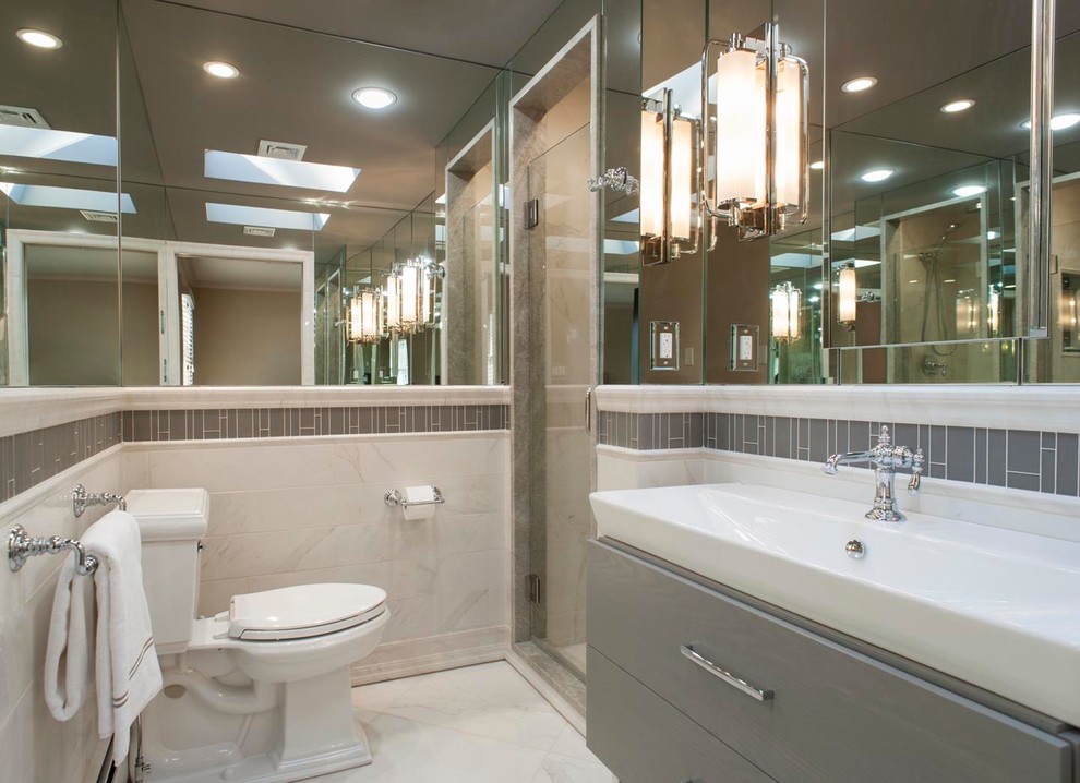 Foto di una piccola stanza da bagno con doccia moderna con ante lisce, ante grigie, piastrelle bianche, pavimento in marmo, doccia alcova, WC a due pezzi, piastrelle in pietra e lavabo rettangolare
