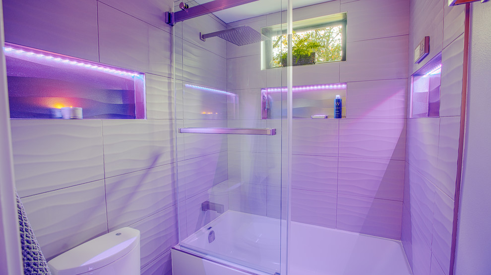 Пример оригинального дизайна: маленькая главная ванная комната в современном стиле с плоскими фасадами, белыми фасадами, накладной ванной, душем над ванной, унитазом-моноблоком, серой плиткой, керамогранитной плиткой, серыми стенами, полом из керамогранита, врезной раковиной, столешницей из искусственного камня, черным полом и душем с раздвижными дверями для на участке и в саду