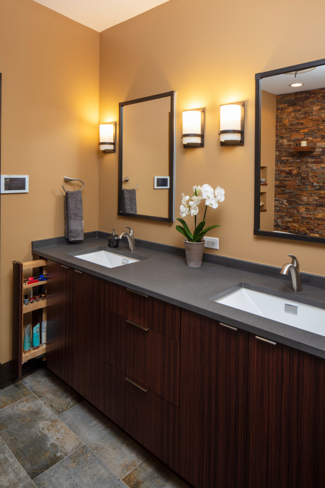 Exemple d'une salle de bain principale montagne en bois foncé avec un placard à porte plane, un mur orange, un sol en carrelage de porcelaine, un lavabo encastré, un plan de toilette en stéatite, un sol gris et un plan de toilette gris.