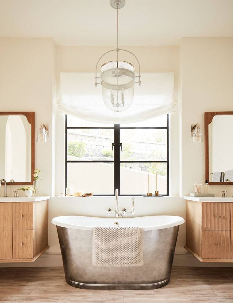 Immagine di una stanza da bagno padronale mediterranea di medie dimensioni con ante in legno chiaro, vasca freestanding, top in quarzite, pavimento marrone, top bianco, pareti beige e ante lisce