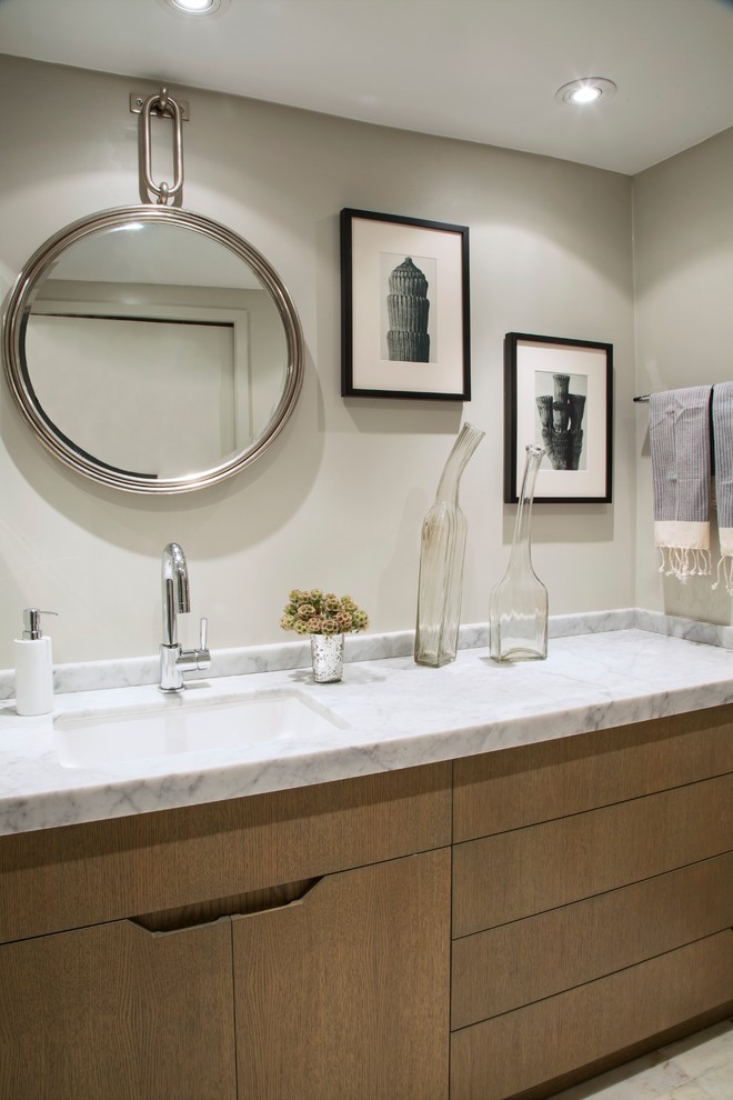 ロサンゼルスにあるコンテンポラリースタイルのおしゃれな浴室 (アンダーカウンター洗面器、フラットパネル扉のキャビネット、中間色木目調キャビネット、大理石の洗面台) の写真