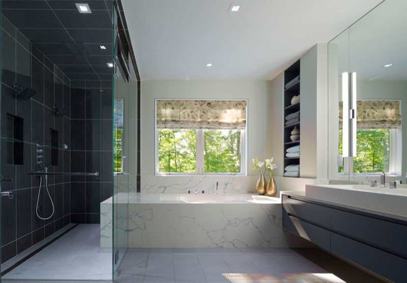 Large modern ensuite bathroom in New York with flat-panel cabinets, grey cabinets, a submerged bath, a corner shower, white walls, a trough sink and a hinged door.