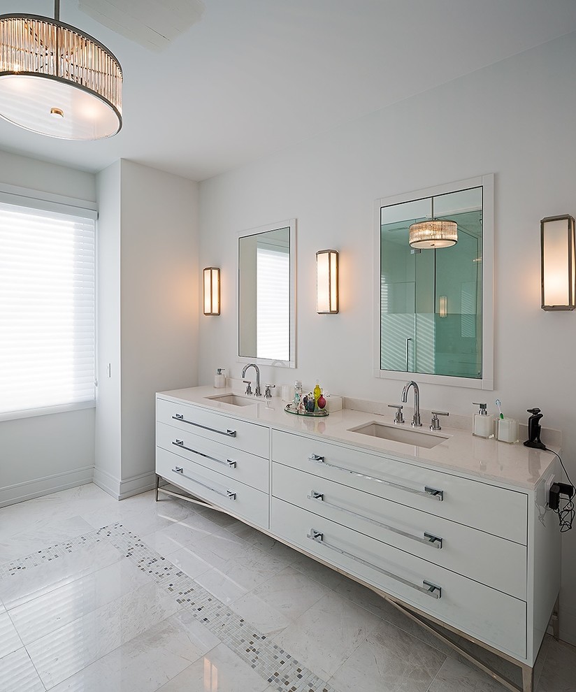 Пример оригинального дизайна: большая главная ванная комната в стиле модернизм с врезной раковиной, плоскими фасадами, белыми фасадами, белой плиткой, белыми стенами, белым полом, угловым душем, душем с распашными дверями и столешницей из искусственного камня