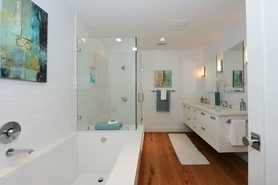 Photo of a medium sized modern ensuite bathroom in Los Angeles with a submerged sink, flat-panel cabinets, white cabinets, solid surface worktops, a built-in bath, a corner shower, white tiles, ceramic tiles, white walls and medium hardwood flooring.
