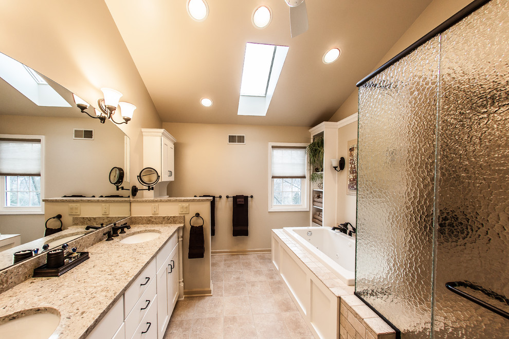Bathroom - mid-sized traditional master beige tile and porcelain tile porcelain tile and brown floor bathroom idea in Other with an undermount sink, white cabinets, flat-panel cabinets, a one-piece toilet, white walls, quartz countertops and a hinged shower door