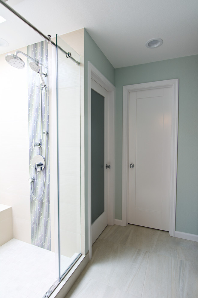 Example of a mid-sized minimalist master beige tile and porcelain tile porcelain tile bathroom design in Seattle with flat-panel cabinets, light wood cabinets, a one-piece toilet, green walls, a vessel sink and quartz countertops