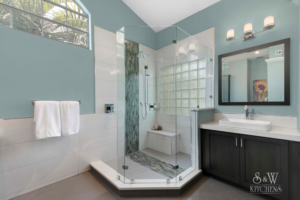 Inspiration for a large contemporary ensuite bathroom in Orlando with shaker cabinets, dark wood cabinets, a walk-in shower, a one-piece toilet, grey tiles, porcelain tiles, blue walls, porcelain flooring, a vessel sink and engineered stone worktops.