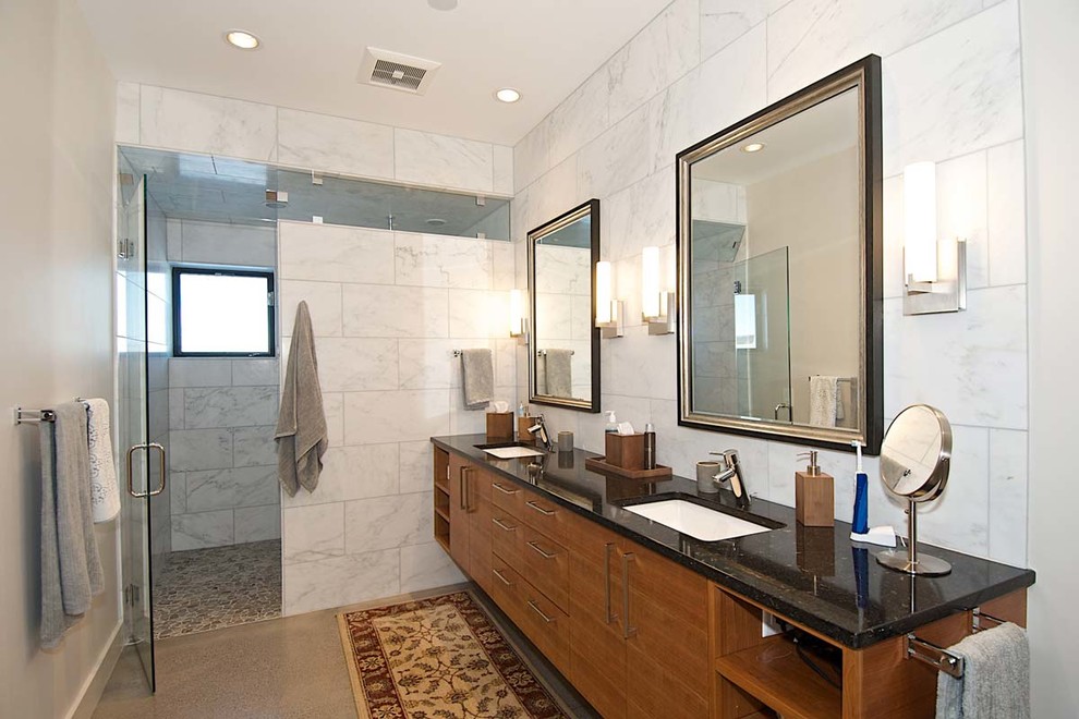 This is an example of a medium sized contemporary ensuite bathroom in Other with flat-panel cabinets, medium wood cabinets, an alcove shower, white tiles, marble tiles, white walls, a submerged sink, brown floors and a hinged door.