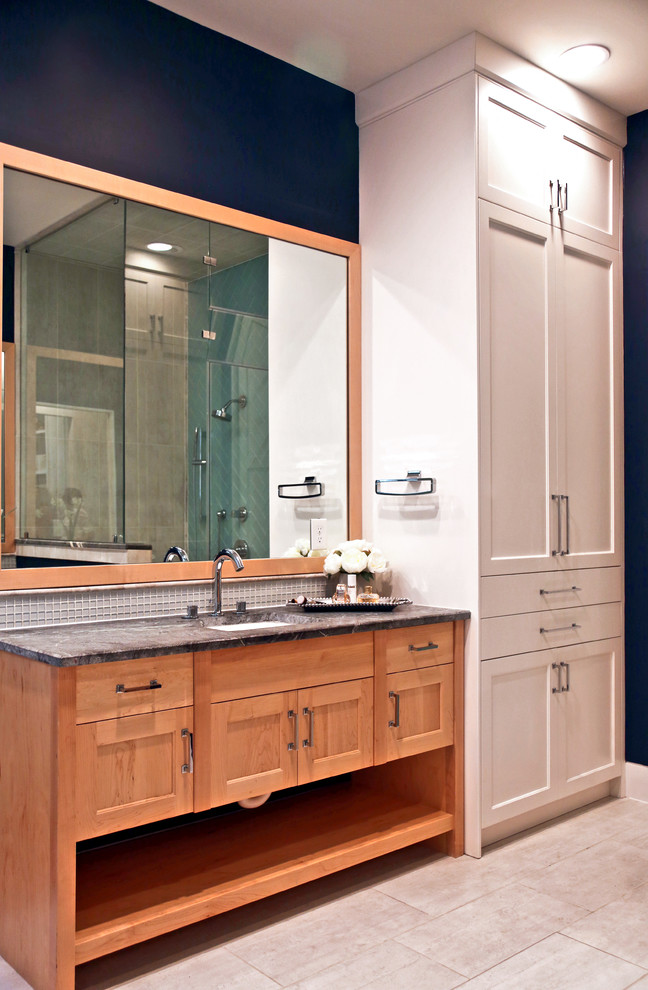 Пример оригинального дизайна: главная ванная комната среднего размера в стиле модернизм с фасадами в стиле шейкер, светлыми деревянными фасадами, отдельно стоящей ванной, душем в нише, белой плиткой, плиткой из листового стекла, синими стенами, полом из керамогранита, врезной раковиной, мраморной столешницей, серым полом, душем с распашными дверями, серой столешницей, тумбой под одну раковину и напольной тумбой
