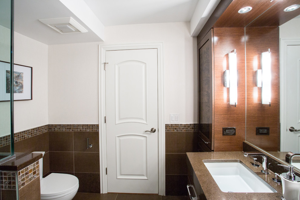 Modern inredning av ett mellanstort badrum, med ett undermonterad handfat, möbel-liknande, skåp i mörkt trä, bänkskiva i kvarts, ett platsbyggt badkar, en dusch i en alkov, en toalettstol med separat cisternkåpa, brun kakel, porslinskakel, vita väggar och klinkergolv i porslin