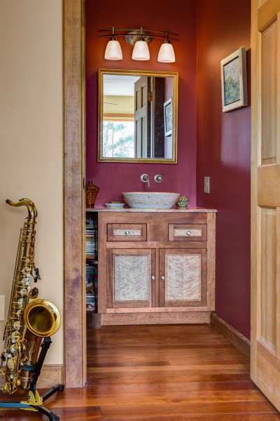 Idée de décoration pour une salle de bain champêtre avec un placard à porte shaker, un mur rouge et un sol en bois brun.