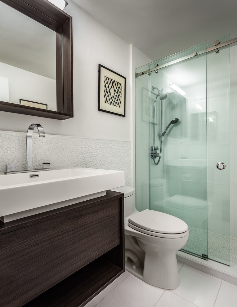 Идея дизайна: маленькая главная ванная комната в современном стиле с плоскими фасадами, темными деревянными фасадами, душем в нише, унитазом-моноблоком, белой плиткой, стеклянной плиткой, белыми стенами, полом из керамогранита и консольной раковиной для на участке и в саду