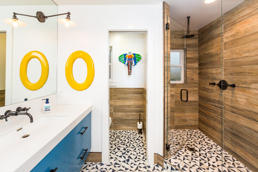 На фото: ванная комната в современном стиле с плоскими фасадами, синими фасадами, душем без бортиков, коричневой плиткой, белыми стенами, душевой кабиной, врезной раковиной, разноцветным полом и душем с распашными дверями