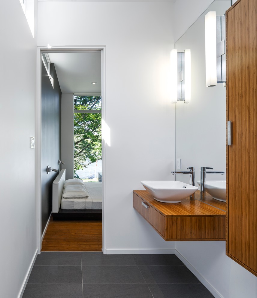На фото: главная ванная комната среднего размера в современном стиле с плоскими фасадами, светлыми деревянными фасадами, белыми стенами, светлым паркетным полом и настольной раковиной с