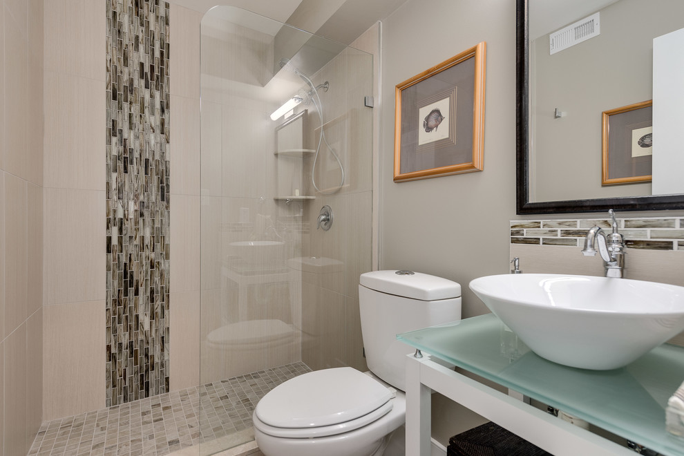 This is an example of a small modern shower room bathroom in DC Metro with open cabinets, white cabinets, a walk-in shower, a two-piece toilet, beige tiles, glass tiles, beige walls, porcelain flooring, a vessel sink and glass worktops.