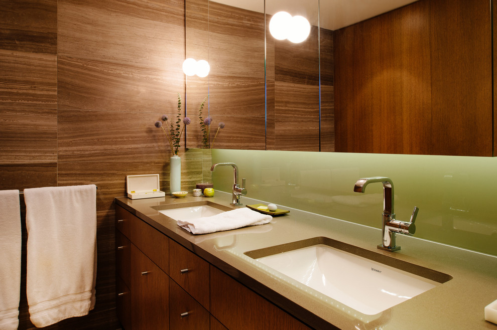Aménagement d'une salle de bain contemporaine en bois brun avec un lavabo encastré et un placard à porte plane.