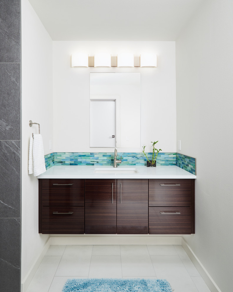 Inspiration for a medium sized contemporary ensuite bathroom in Portland with flat-panel cabinets, dark wood cabinets, an alcove shower, a two-piece toilet, blue tiles, glass tiles, white walls, porcelain flooring, a submerged sink, engineered stone worktops, white floors, a hinged door and white worktops.