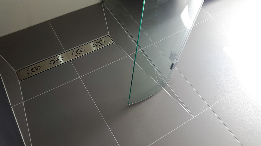 Medium sized modern bathroom in Manchester with white cabinets, a freestanding bath, a wall mounted toilet, multi-coloured tiles, porcelain tiles, multi-coloured walls, porcelain flooring, a trough sink, multi-coloured floors and a hinged door.