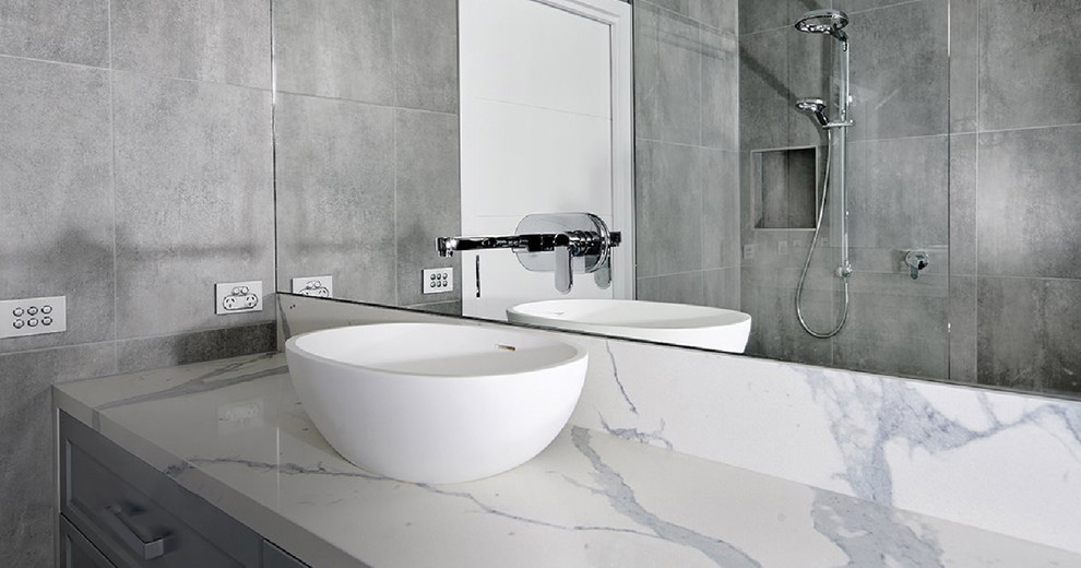 Inspiration för mellanstora moderna vitt badrum, med luckor med infälld panel, grå skåp, grå kakel, bänkskiva i terrazo och ett fristående handfat