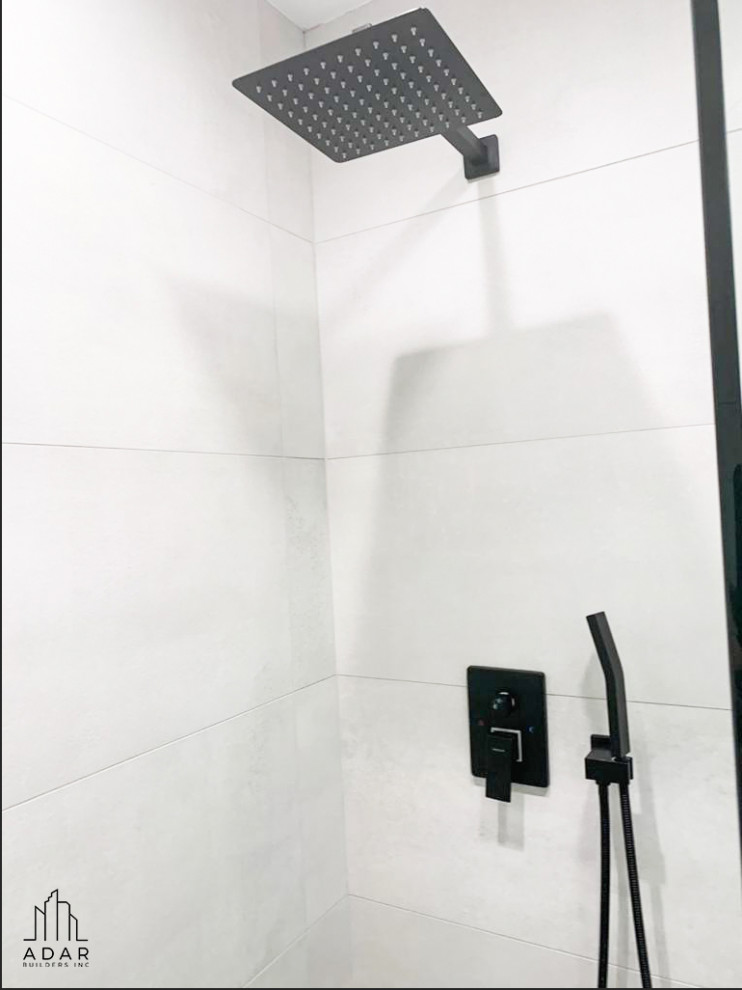 Modern inredning av ett mellanstort vit vitt badrum för barn, med släta luckor, vita skåp, en dusch i en alkov, vita väggar, marmorgolv, ett integrerad handfat, marmorbänkskiva och vitt golv