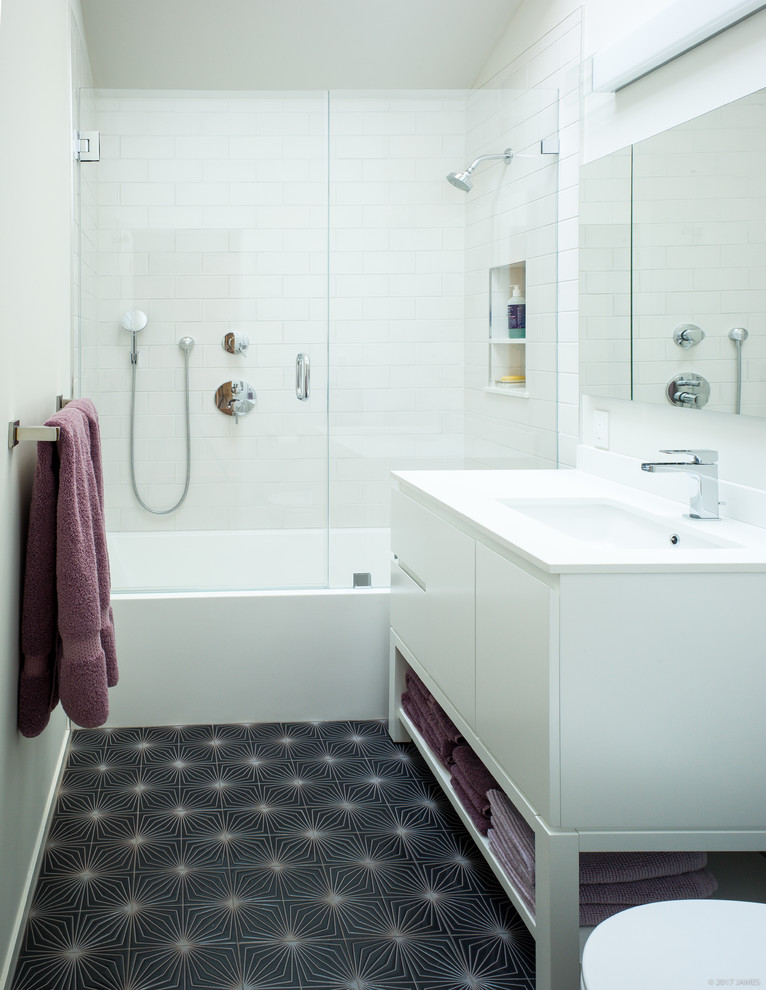 Идея дизайна: маленькая ванная комната в стиле модернизм с плоскими фасадами, белыми фасадами, ванной в нише, унитазом-моноблоком, белой плиткой, керамической плиткой, белыми стенами, врезной раковиной, столешницей из искусственного кварца, серым полом, душем с распашными дверями, душем над ванной и полом из керамической плитки для на участке и в саду