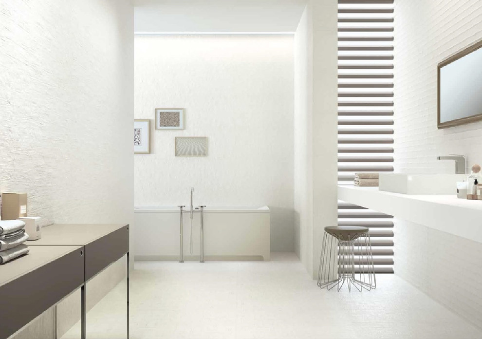 Idée de décoration pour une grande salle de bain principale minimaliste avec un placard à porte plane, une baignoire indépendante, un carrelage blanc, des carreaux de porcelaine, un mur blanc, une vasque et un sol blanc.
