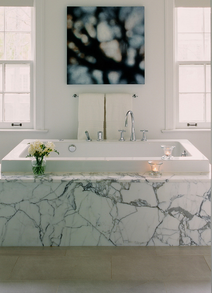 На фото: ванная комната в стиле модернизм с накладной ванной, белой плиткой и мраморной плиткой