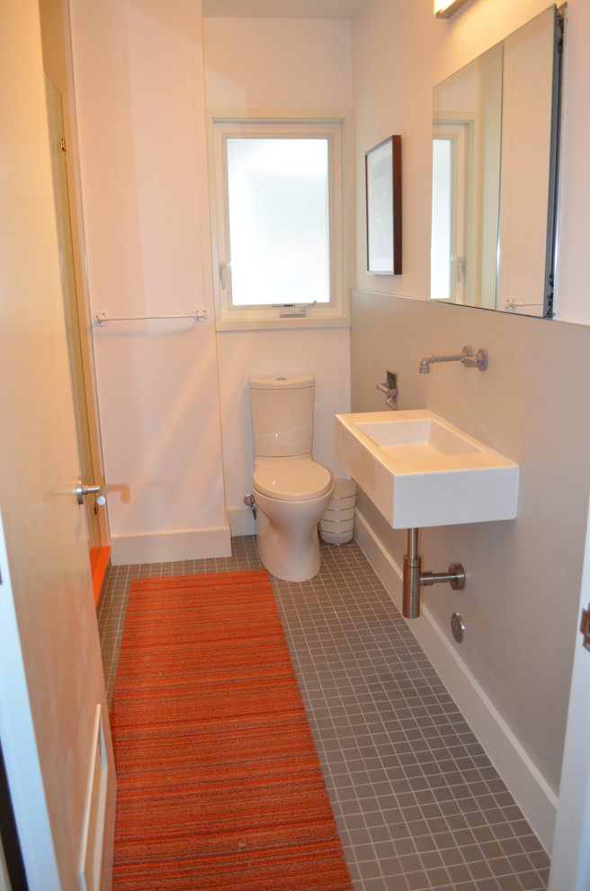 Ejemplo de cuarto de baño actual con puertas de armario blancas, ducha abierta, sanitario de una pieza, baldosas y/o azulejos multicolor, paredes blancas y suelo de cemento