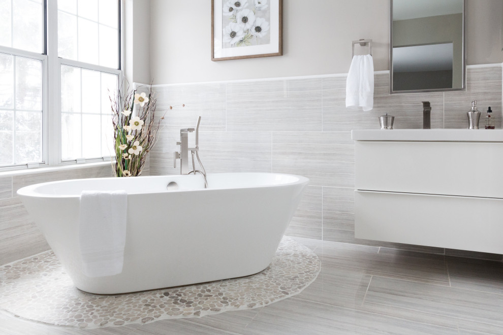 Пример оригинального дизайна: маленькая главная ванная комната в стиле модернизм с плоскими фасадами, белыми фасадами, отдельно стоящей ванной, душем в нише, унитазом-моноблоком, серой плиткой, керамогранитной плиткой, серыми стенами, полом из керамогранита, врезной раковиной, мраморной столешницей, серым полом, душем с распашными дверями и белой столешницей для на участке и в саду
