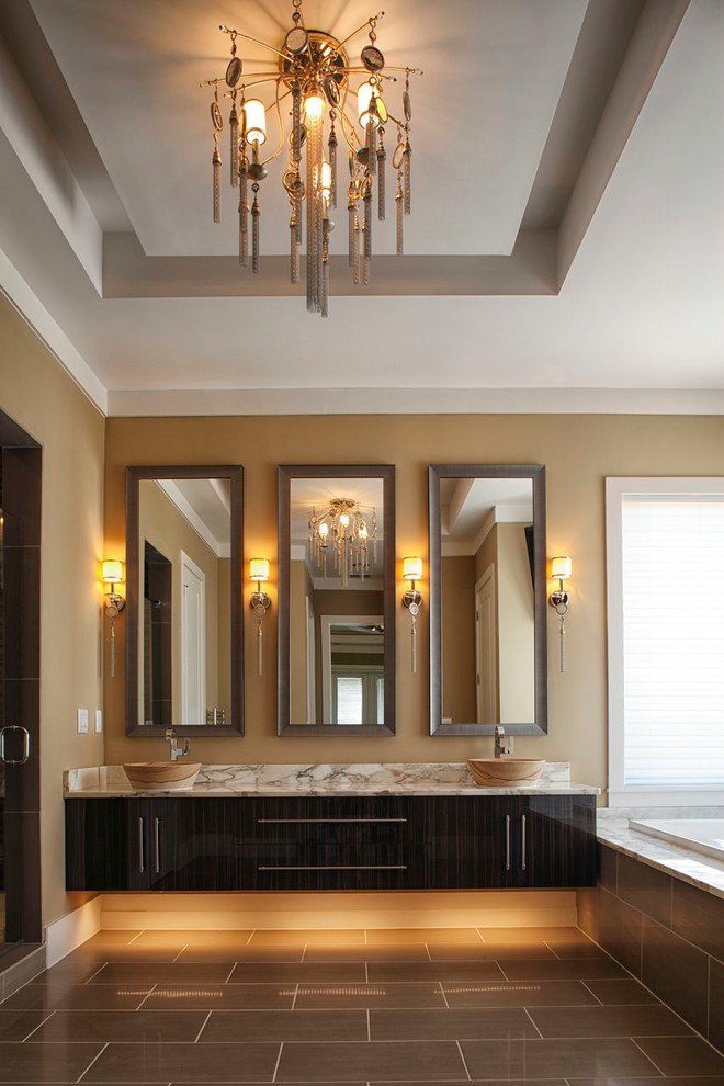 Imagen de cuarto de baño contemporáneo con lavabo sobreencimera, armarios con paneles lisos, puertas de armario de madera en tonos medios, bañera encastrada y baldosas y/o azulejos marrones